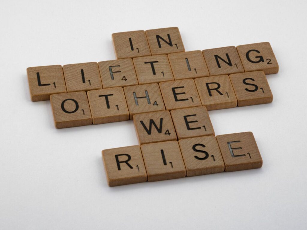 Wooden Scrabble tiles spelling uplifting message on a clean white backdrop.